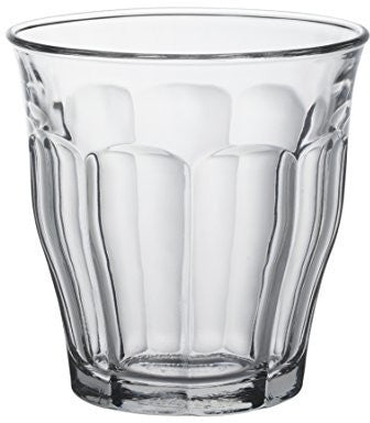 Clear glass tumbler with textured design on a white background