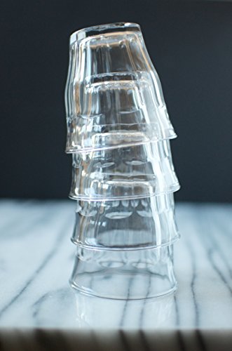 Stack of clear plastic cups on a marble surface with a dark background